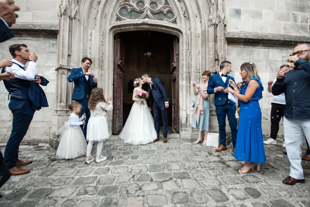 Photo des mariées a la sortie de l'église entouré des invités, photo prise par Quentin Viel